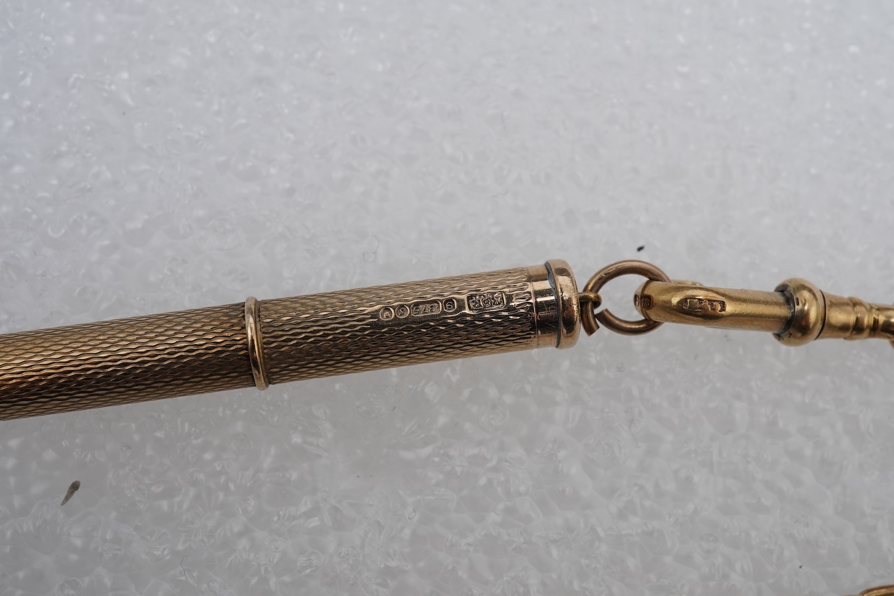A gold watch chain, toothpick and fob seal